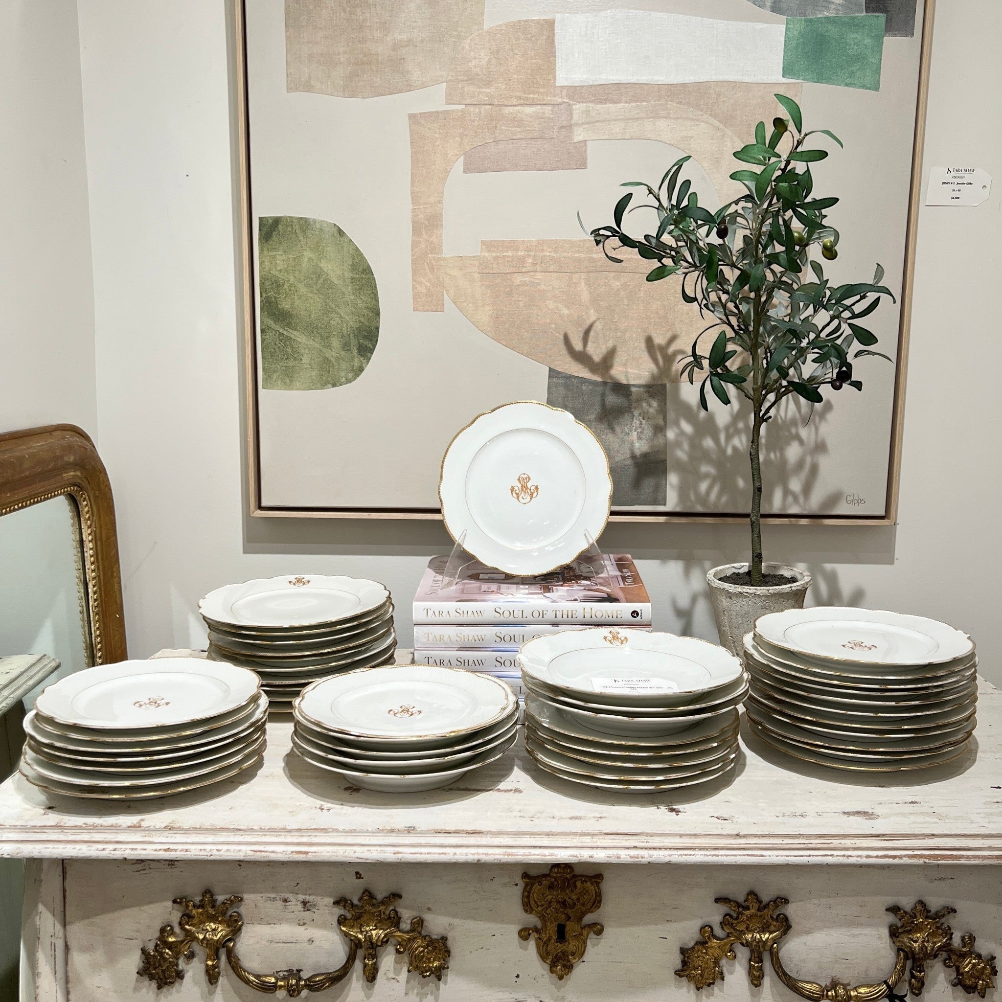 Antique dessert and salad plate set with gold MS monogram and scalloped edges displayed on a rustic table.