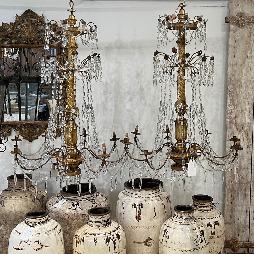 Tara Shaw 18th century Genoese chandelier with aged patina, scrolling arms, and crystal drops in a grand interior.
