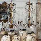 Tara Shaw 18th century Genoese chandelier with aged patina, scrolling arms, and crystal drops in a grand interior.
