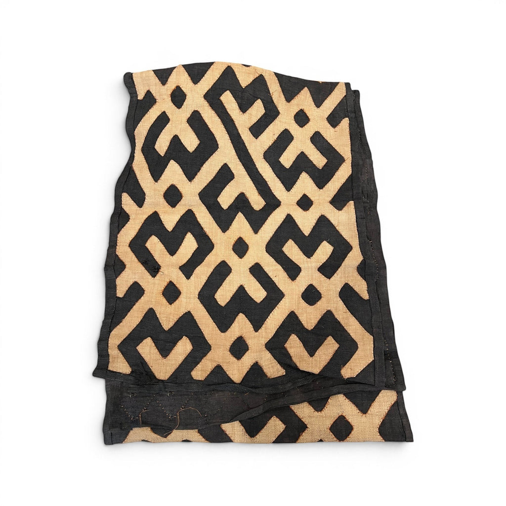 Tara Shaw African Kuba cloth long runner with intricate black and tan geometric patterns and handwoven texture.