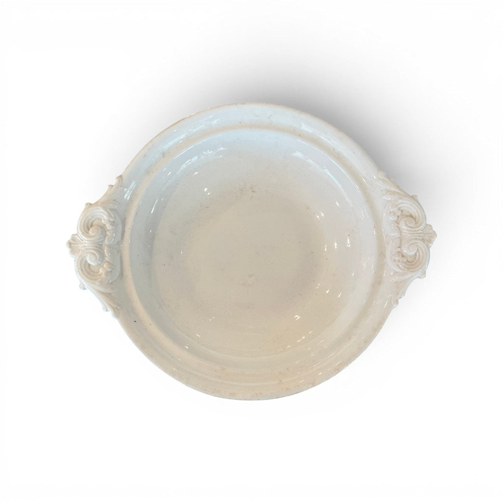 Tara Shaw 19th century European ironstone bowl with ornate handles and aged white patina, top-down view.