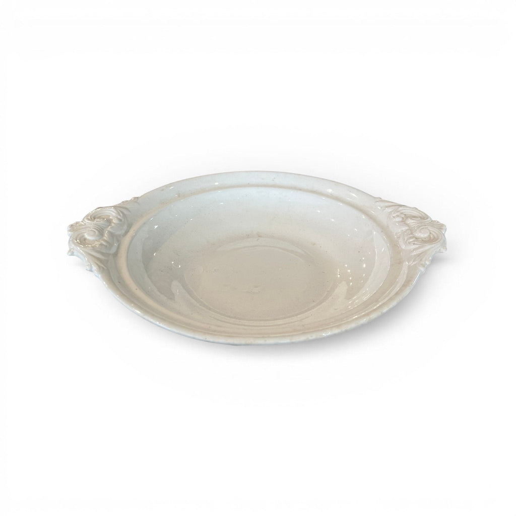 Tara Shaw 19th century European ironstone bowl with ornate handles and a weathered cream patina.