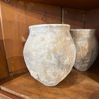 Tara Shaw 18th-century Spanish rustic pottery jar with a weathered, textured patina on a wooden shelf.