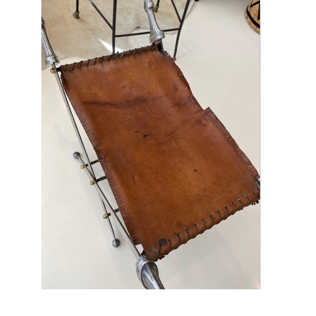 Tara Shaw pair of folding sword stools with argenté metal frames and brown leather seats in a campaign style.