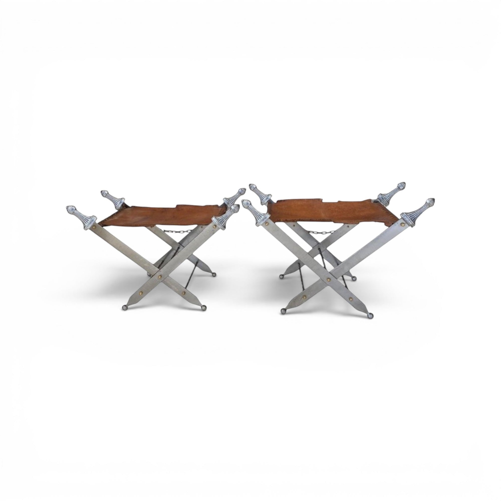 Tara Shaw pair of folding sword stools with argenté metal frames and brown leather seats in a campaign style.