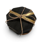 Tara Shaw set of four black octagonal coasters with gold accents tied together with rustic twine.