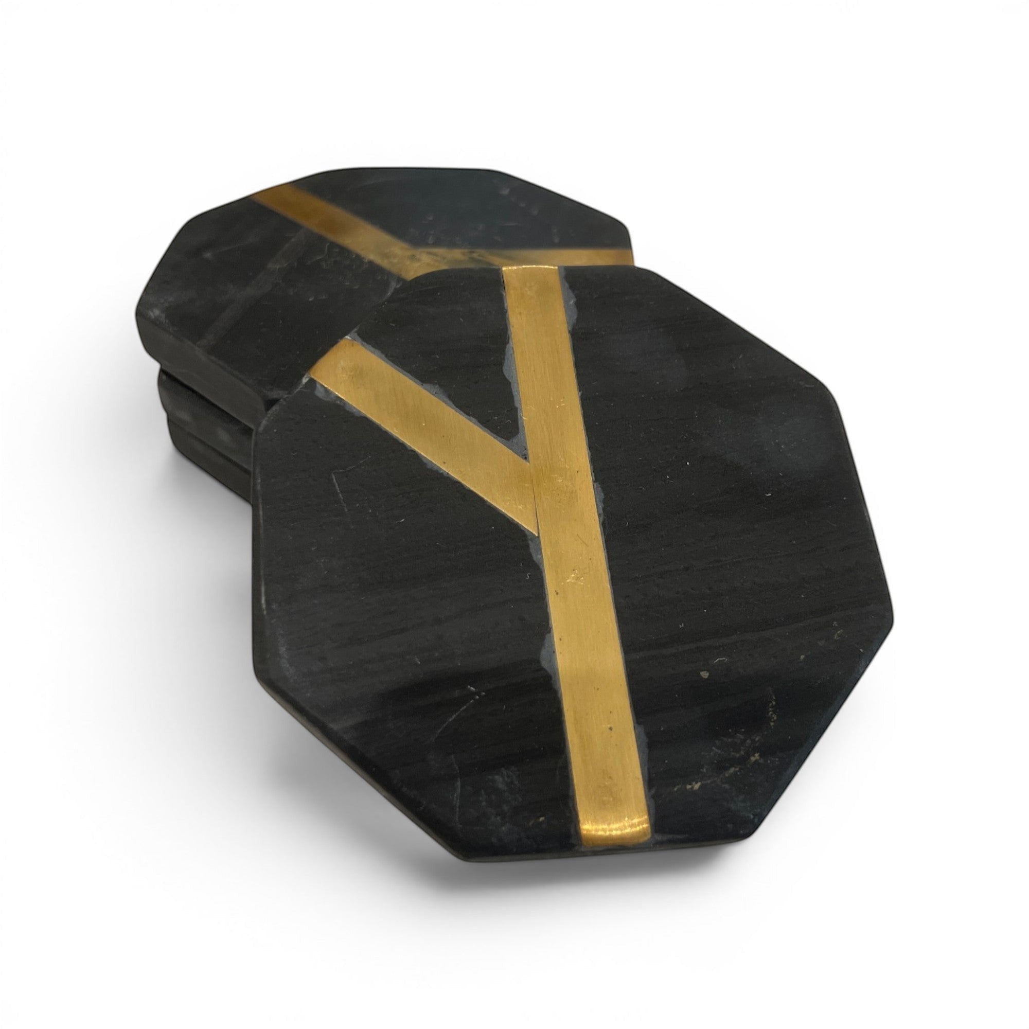 Tara Shaw black octagonal coasters with gold inlay detail stacked on a white background