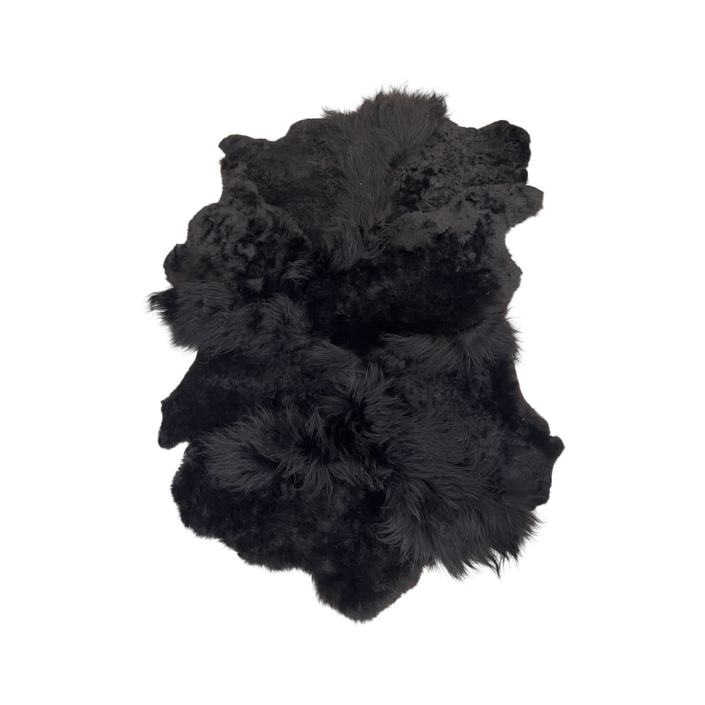 Tara Shaw black sheepskin rug with a textured high-low pile for a luxurious and modern interior accent.