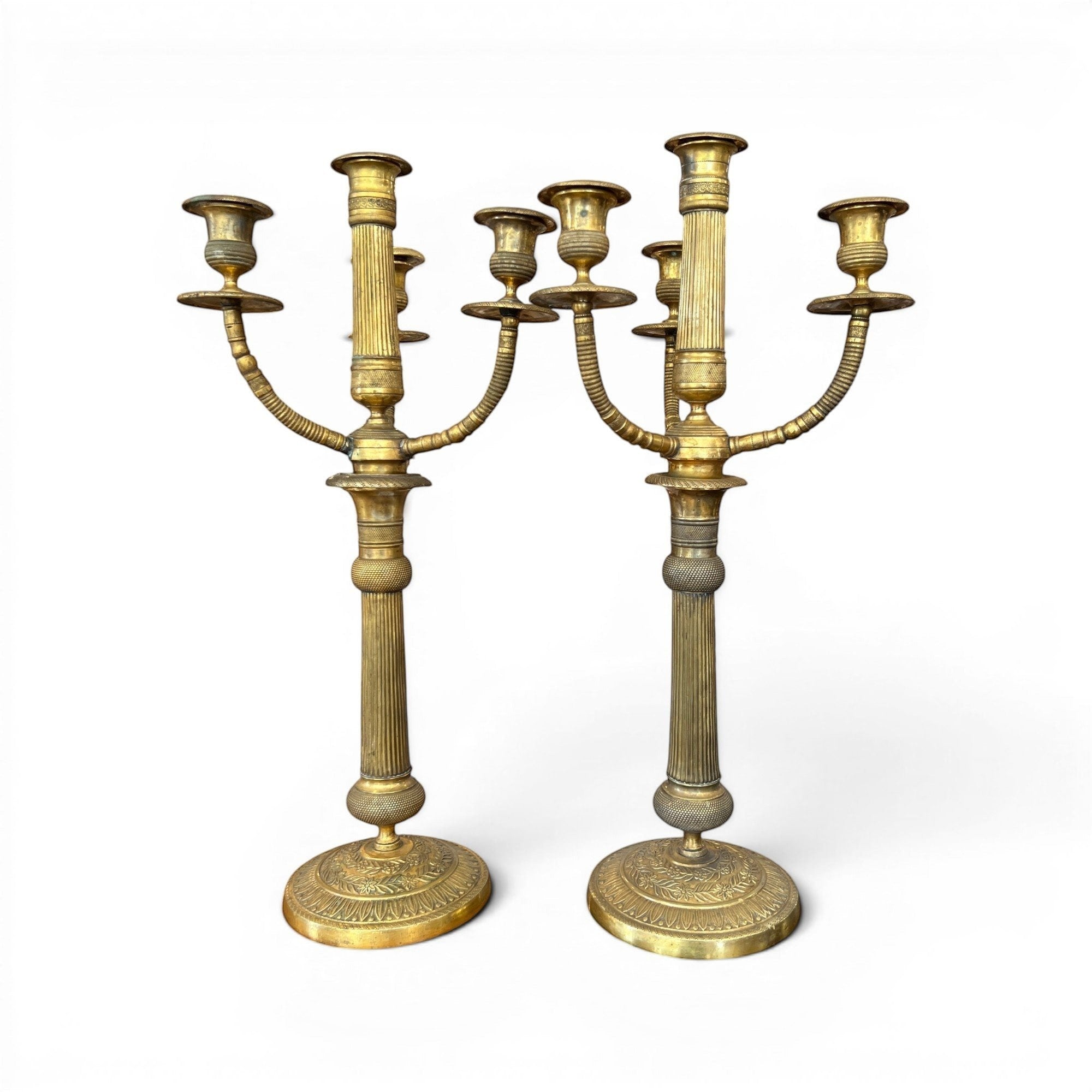 Tara Shaw pair of early 20th-century brass candelabras with aged patina and elegant European sculptural design.