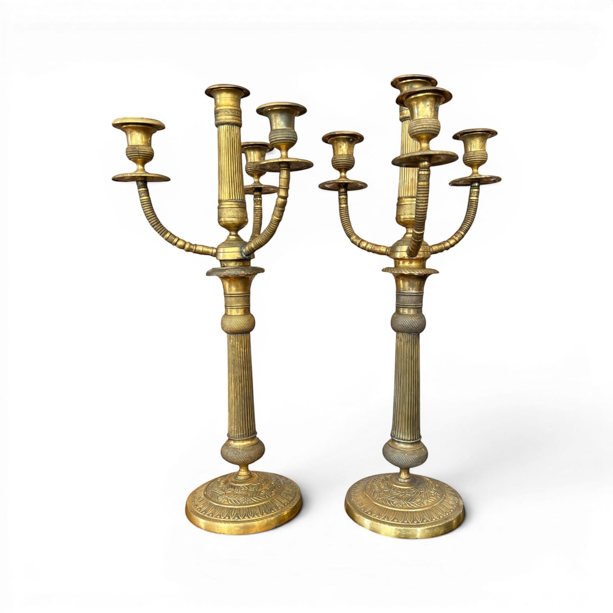Tara Shaw pair of early 20th-century brass candelabras with aged patina and elegant European sculptural design.