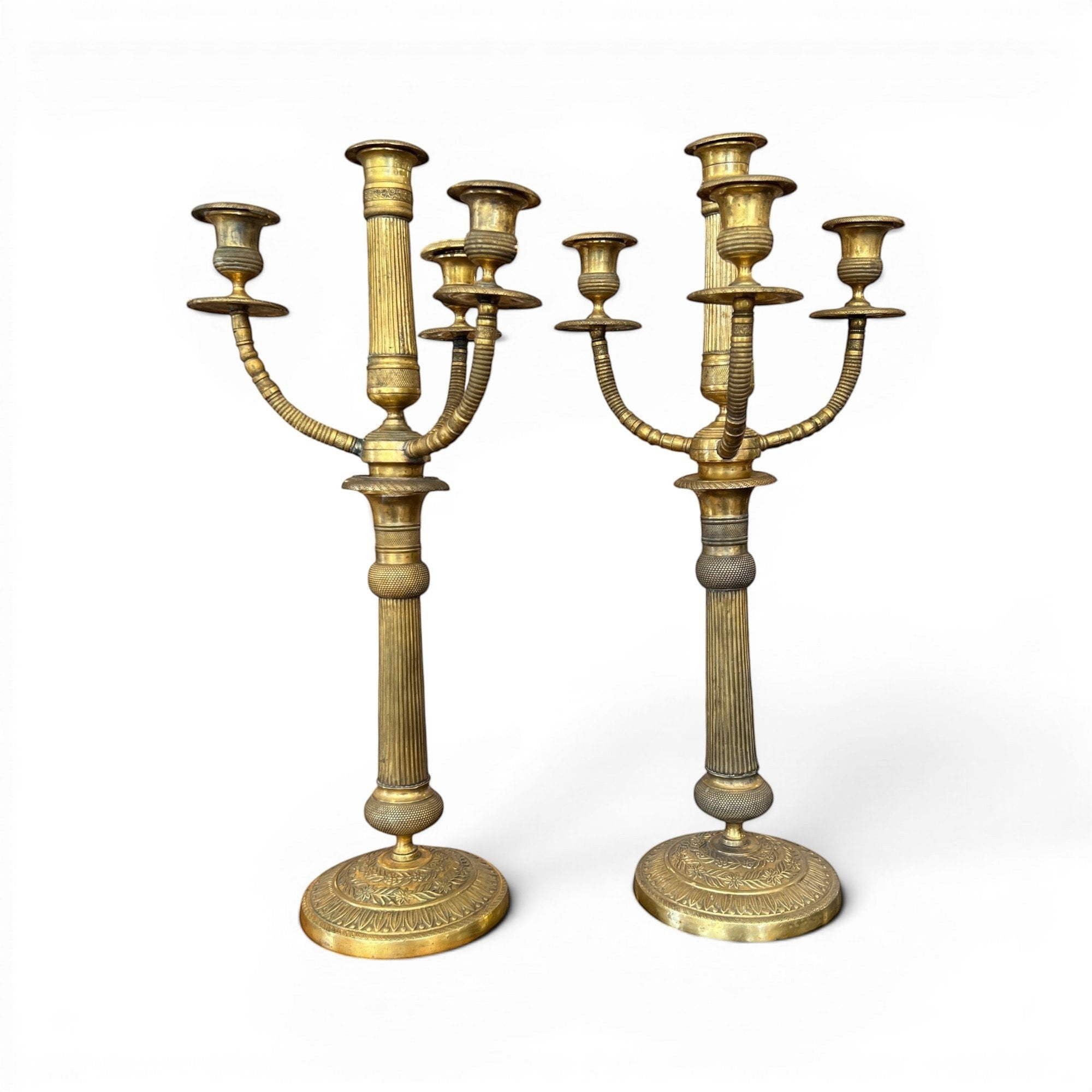 Tara Shaw pair of early 20th-century brass candelabras with aged patina and classic European sculptural design.