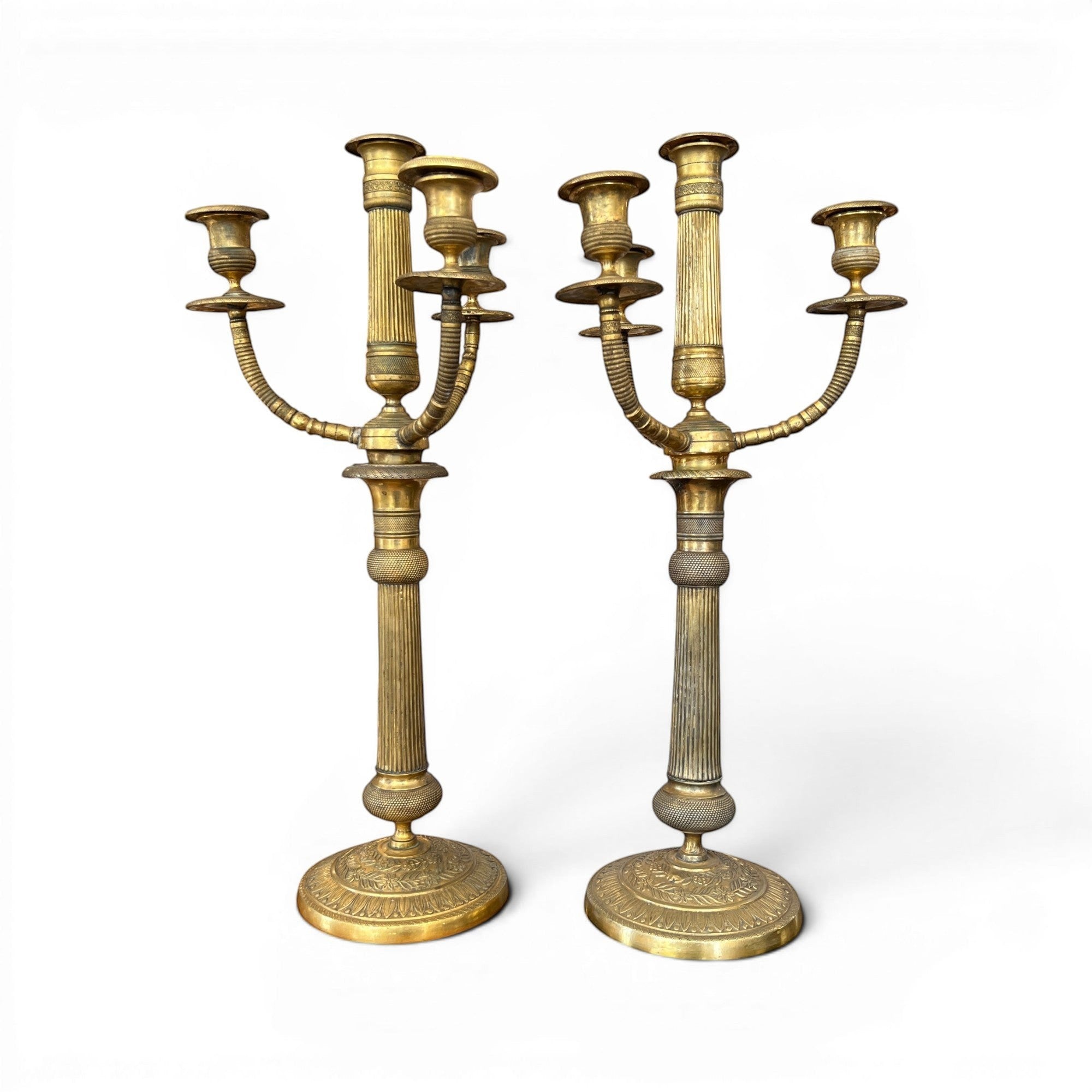 Tara Shaw pair of early 20th-century brass candelabras with aged patina and elegant European sculptural design.