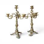 Tara Shaw pair of early 20th-century bronze candelabras with ornate sculptural leaf detailing and aged patina.