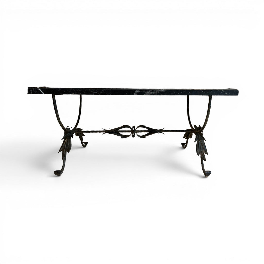 Tara Shaw coffee table with a polished black marble top and a sculptural bronze leaf base on a white background.