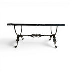 Tara Shaw coffee table with a polished black marble top and a sculptural bronze leaf base on a white background.