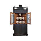 Tara Shaw 18th-century Italian ebonized corner cabinet with open glass doors and antique pottery on wooden shelves.