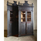 Tara Shaw 18th century Italian corner cabinet with an ebonized finish, glass doors, and architectural detailing.