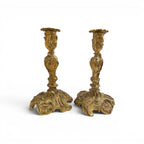Tara Shaw pair of 19th-century French Louis XV bronze candle holders with intricate rococo detailing and aged patina.