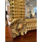 Tara Shaw 19th century French Empire mirror with gold ripple frame and ornate medallion corner detail.
