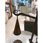 Tara Shaw 19th-century French iron candleholder with a conical shade and aged patina on a marble table.