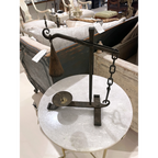 Tara Shaw 19th-century French iron candleholder with an aged patina and hanging bell detail on a marble table.