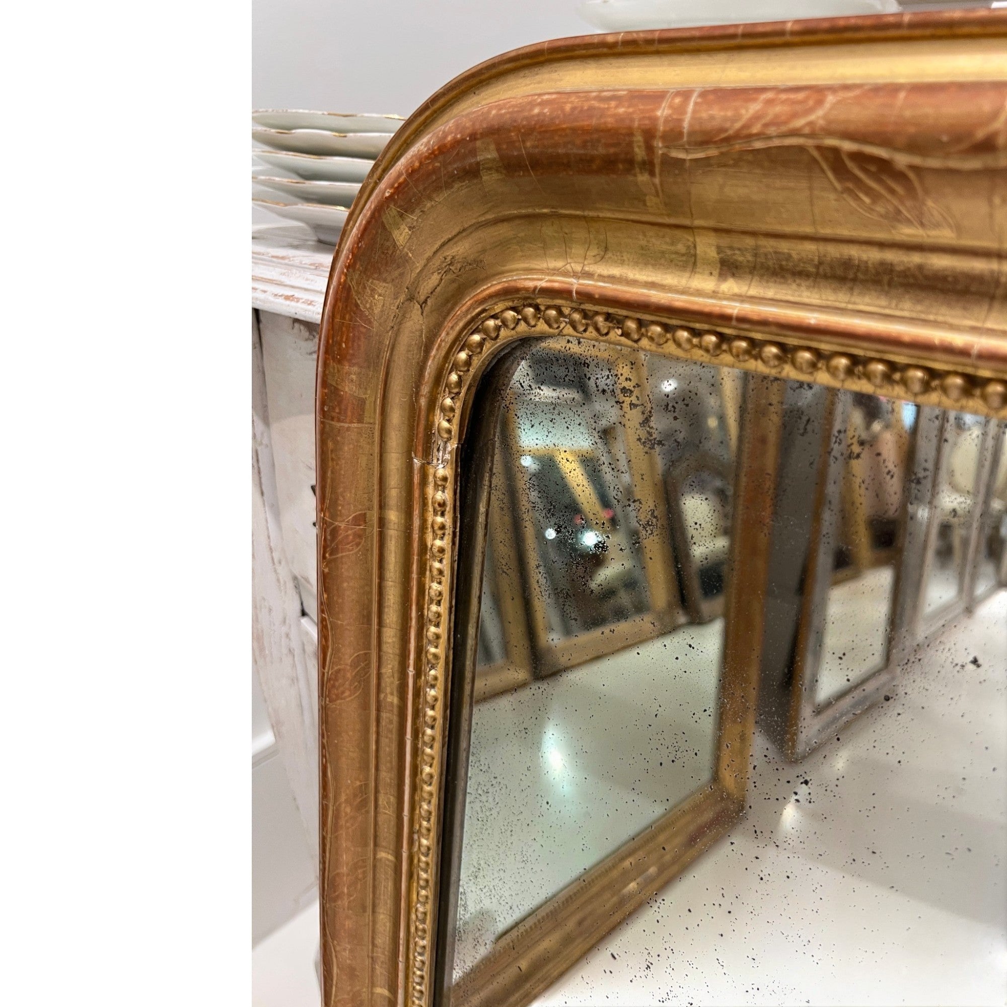 Tara Shaw 19th century French Louis Philippe mirror featuring a curved gilded frame with delicate floral carvings