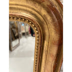 Tara Shaw 19th century French Louis Philippe mirror featuring a curved gilded frame with delicate floral detailing.