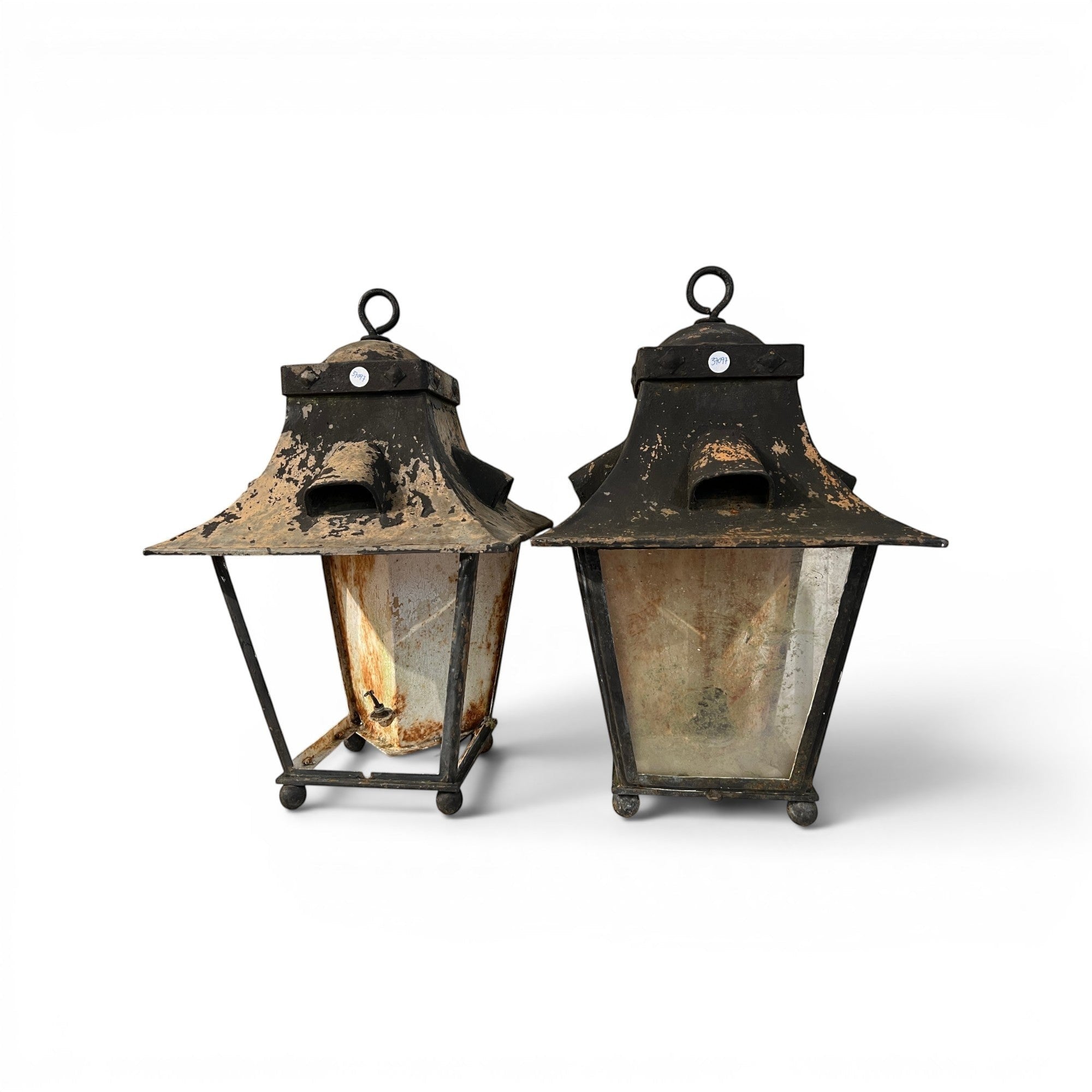 Tara Shaw pair of 19th-century French wall lanterns with aged black metalwork and weathered glass panels.