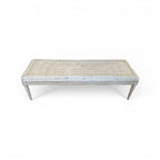 Tara Shaw 19th-century Gustavian backless bench with a tufted beige cushion and distressed wood frame.