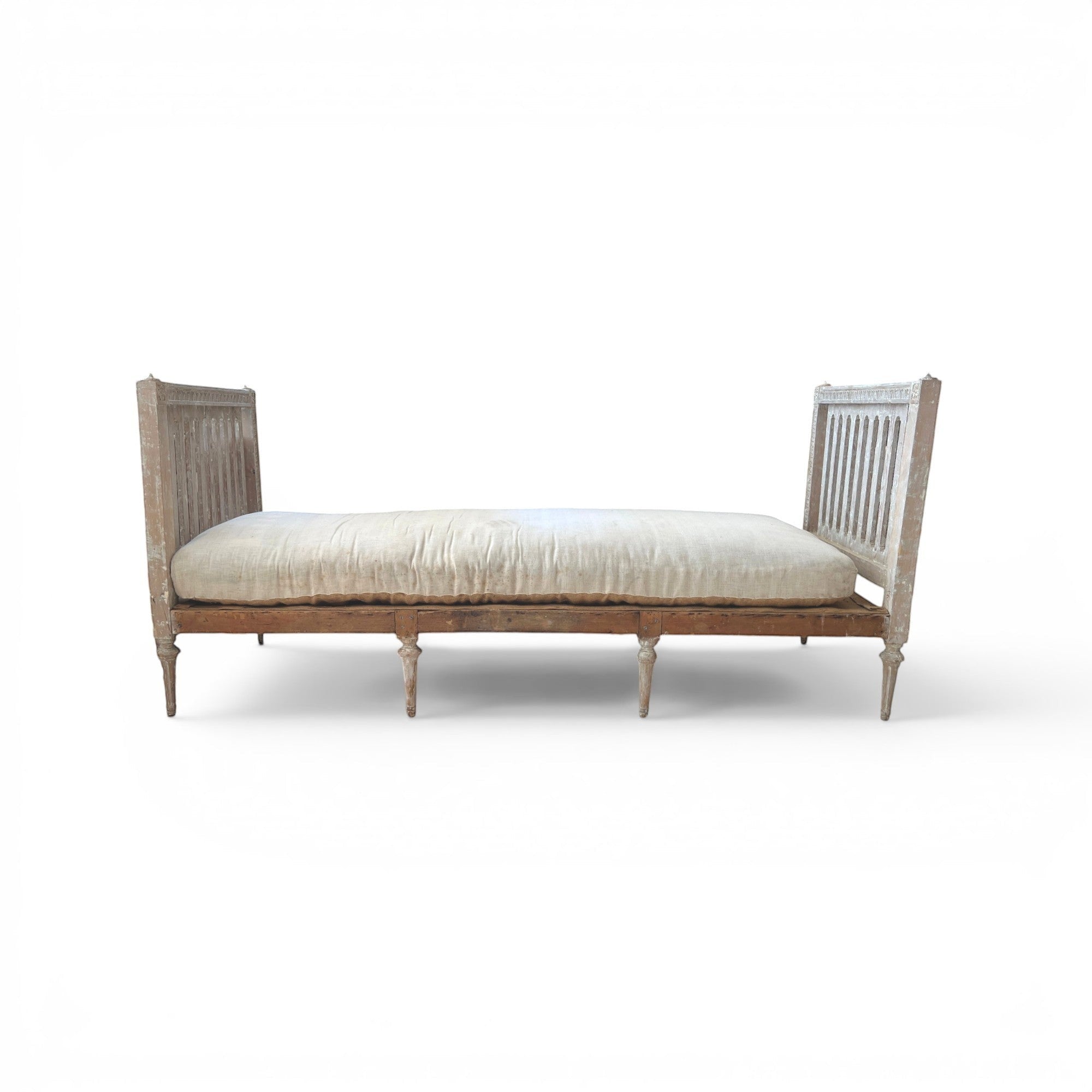 Tara Shaw 18th-century Gustavian daybed with carved wood frame, aged patina, and neutral linen upholstered cushion.