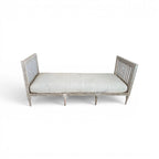 Tara Shaw 18th century Gustavian daybed with carved wood frame, aged patina, and neutral linen upholstered cushion.