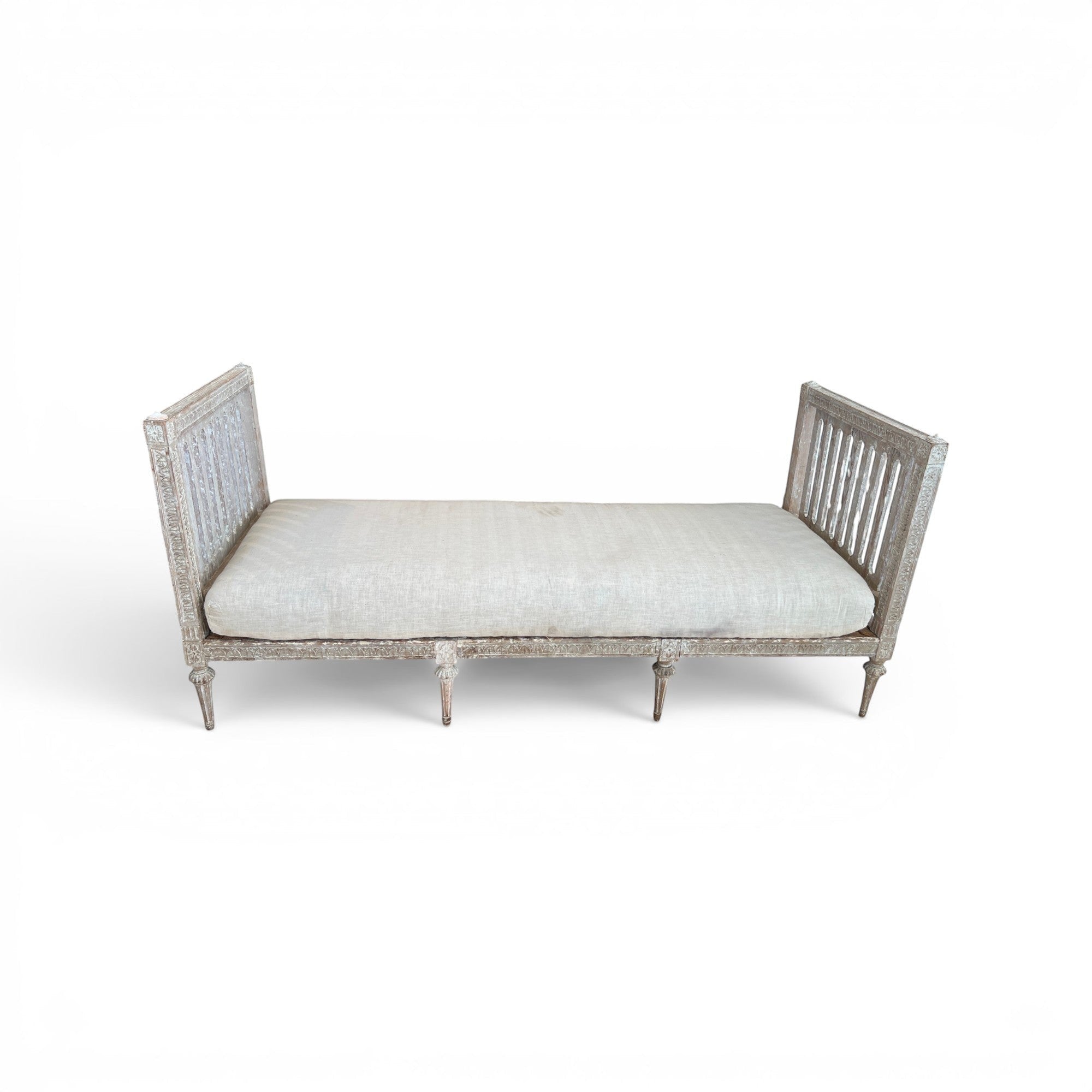 Tara Shaw 18th century Gustavian daybed with carved wood frame, aged patina, and neutral linen upholstered cushion.