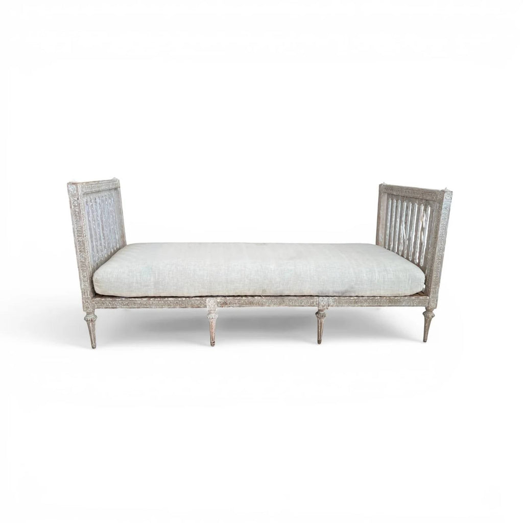 Tara Shaw 18th century Gustavian daybed with carved wood frame, aged patina, and light linen upholstered cushion.