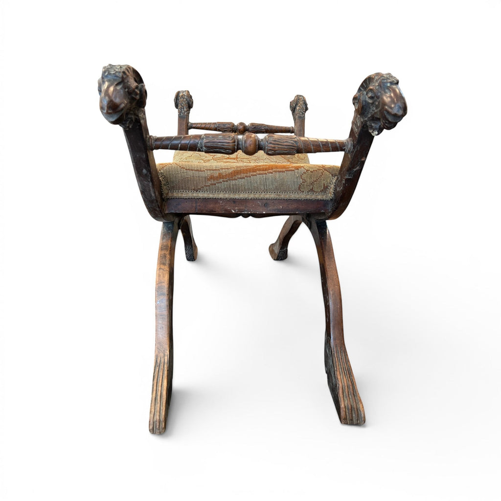 Tara Shaw 19th-century Italian walnut curule stool featuring carved ram's head finials and a classic crossed-leg base.