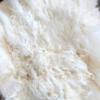 Tara Shaw ivory Tibetan lambskin throw featuring long, plush, and curly natural wool texture for home decor.
