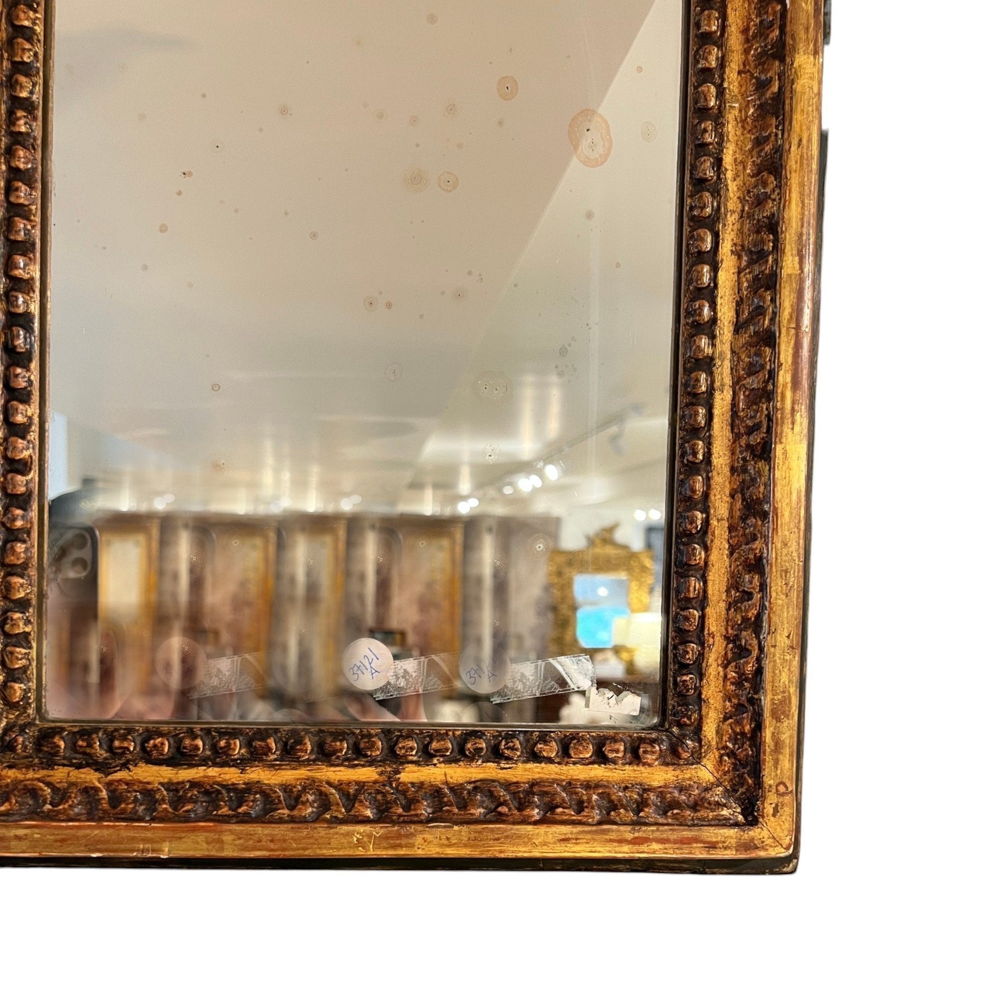 Tara Shaw 18th Century French Louis XVI antique mirror with a carved gold frame and aged patina detail.