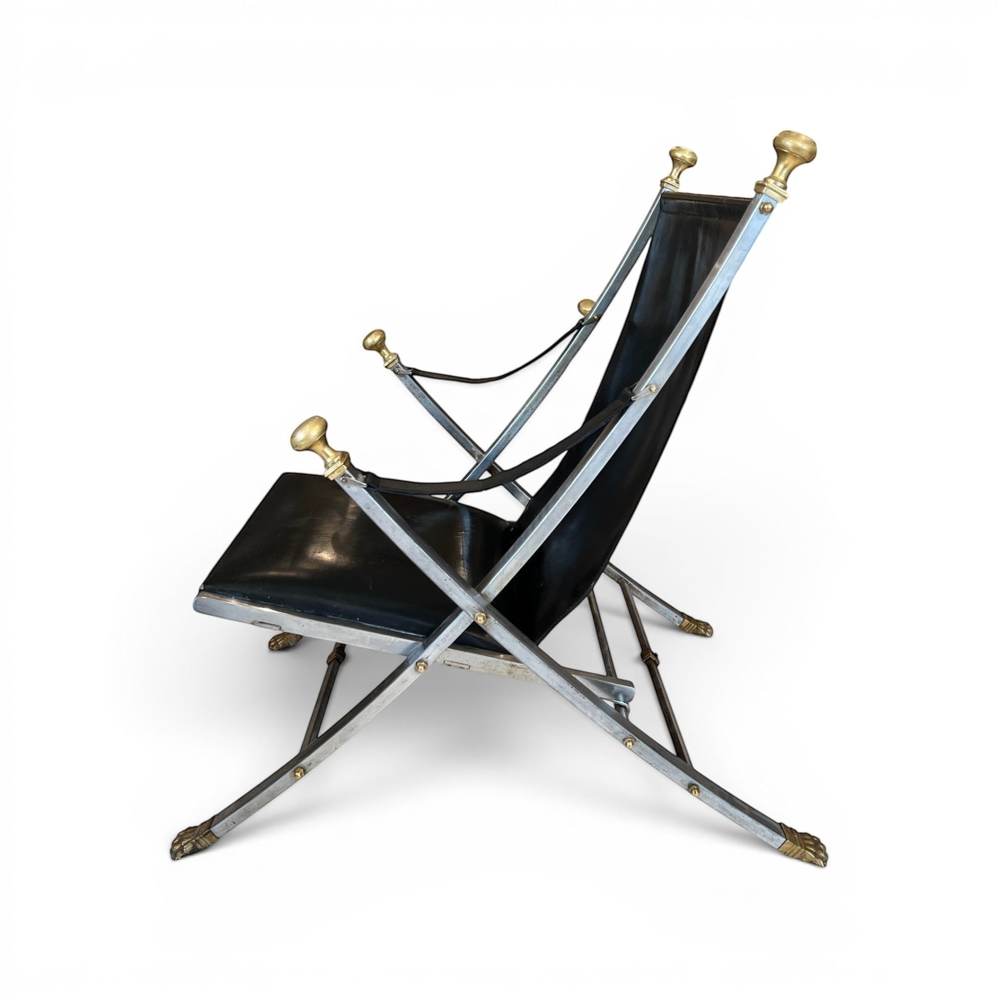 Tara Shaw vintage Maison Jansen folding chair with black leather seat and brass-toned metal frame, side view.