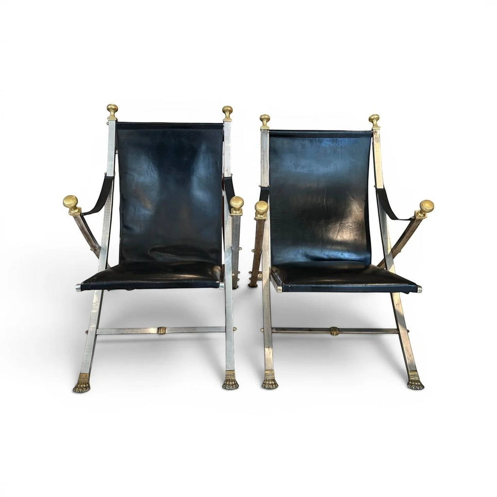 Tara Shaw pair of vintage Maison Jansen folding chairs with black leather seats and brass-toned metal frames.