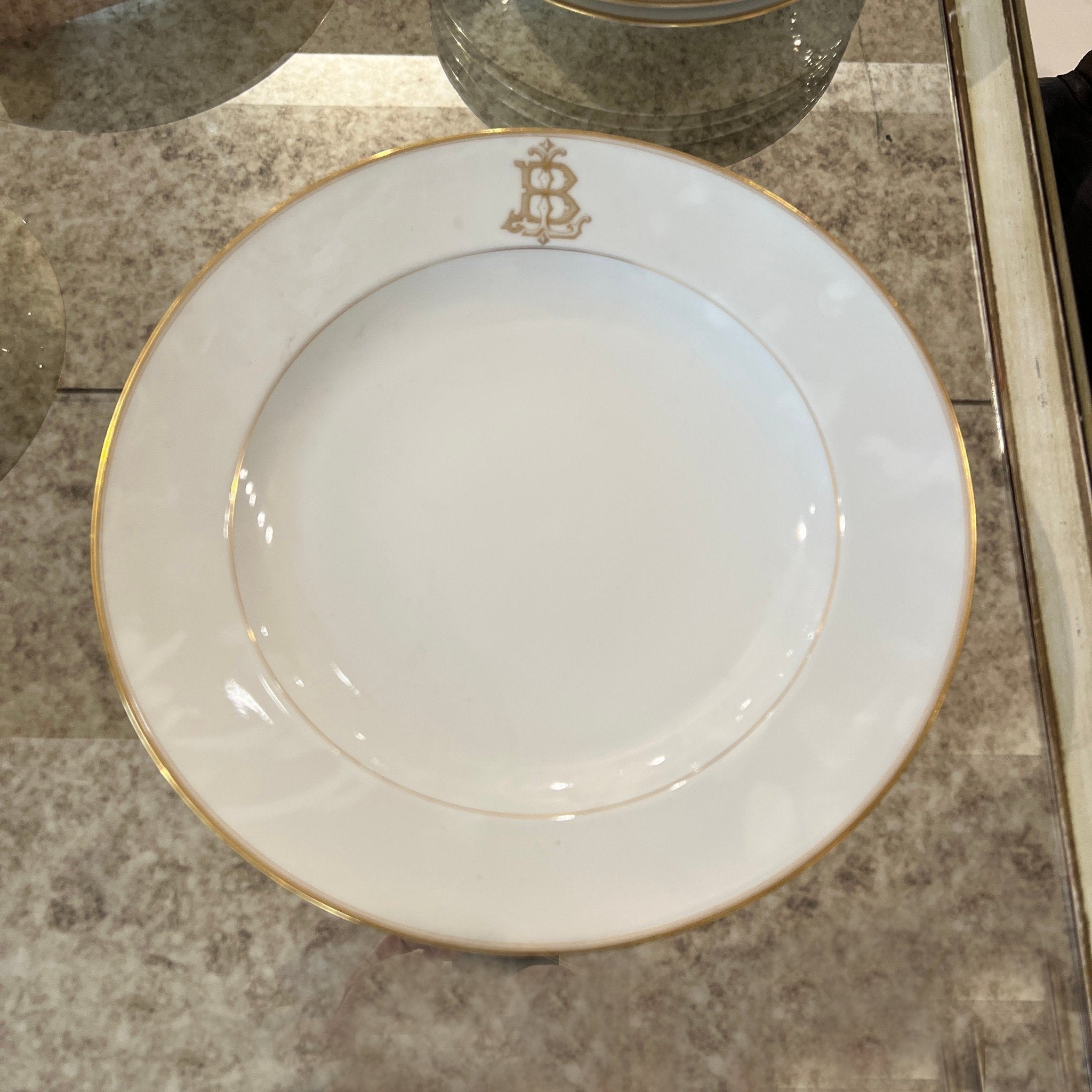 Tara Shaw French china dinner plate featuring a gold monogrammed B and elegant gold rim detailing.