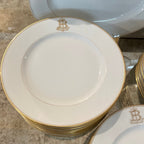 Tara Shaw French china plates featuring a gold monogrammed B and elegant gold rim detailing.