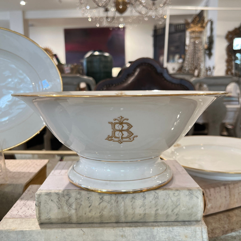 Tara Shaw white porcelain bowl with gold rim and elegant monogrammed B, displayed on vintage books.