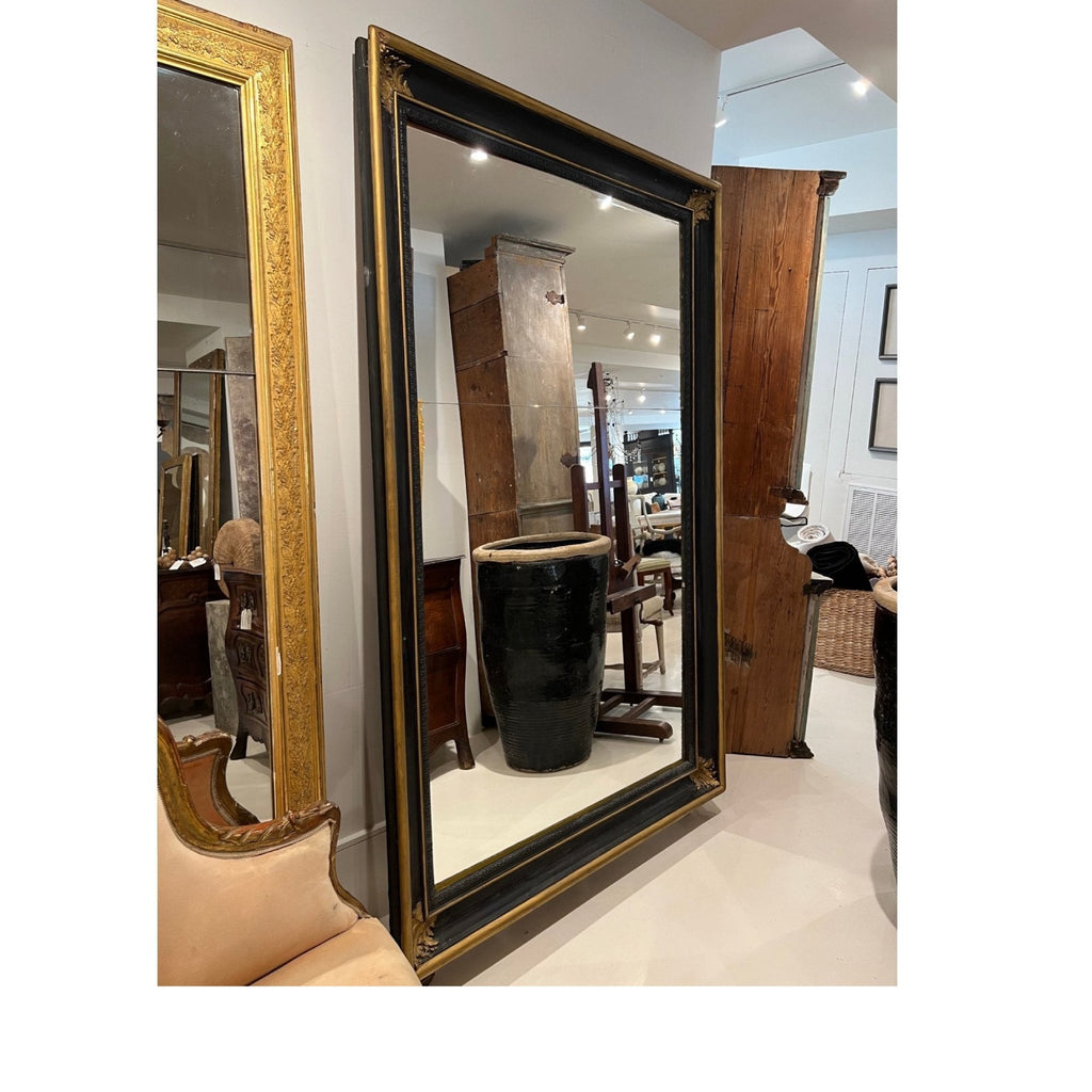 Tara Shaw 19th century French Napoleon III floor mirror with a black and gilt frame in a showroom setting