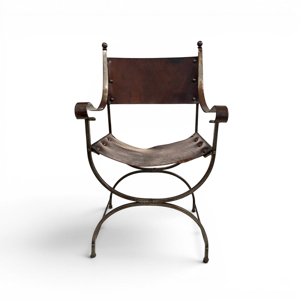Tara Shaw early 20th century Savonarola chair with a sculptural metal frame and aged brown leather seat.