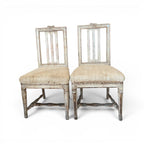 Tara Shaw pair of 18th-century Swedish chairs with distressed white paint, carved details, and natural linen seats.
