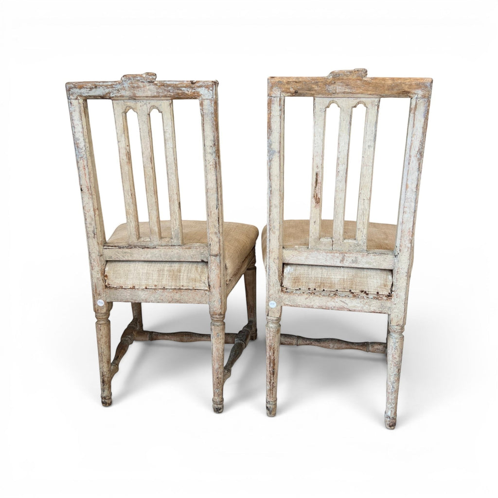Tara Shaw pair of 18th-century Swedish chairs with distressed white paint, carved wood details, and linen seats.
