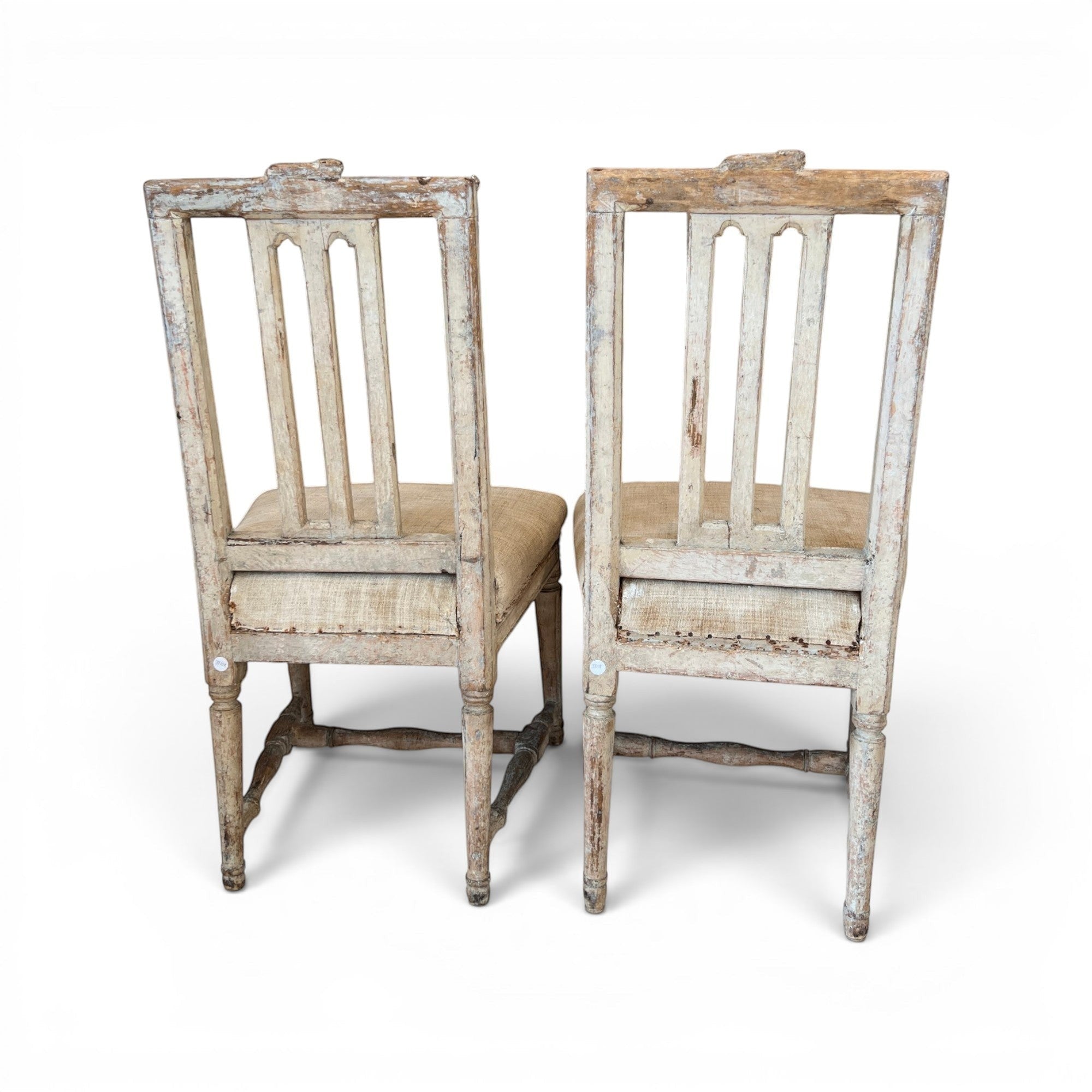 Tara Shaw pair of 18th-century Swedish chairs with distressed white paint, carved wood details, and linen seats.