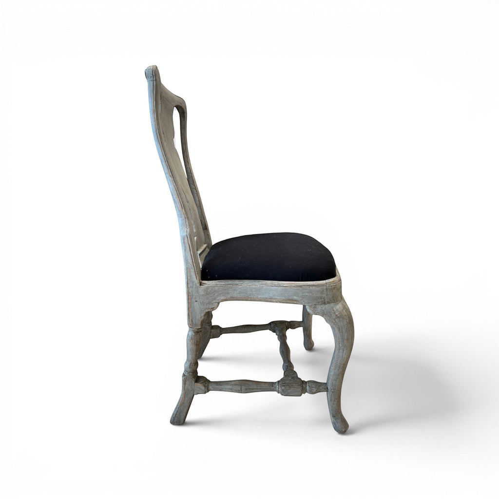 Tara Shaw 18th century Swedish Rococo dining chair with aged grey wood finish and black upholstered seat, side view.