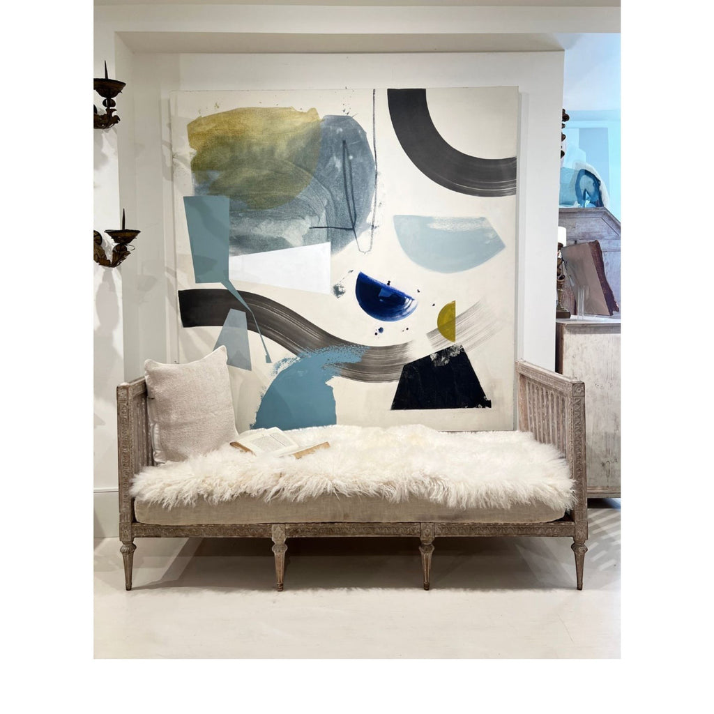 Tara Shaw ivory Tibetan lambskin throw draped over a vintage wooden bench with a plush, organic texture.
